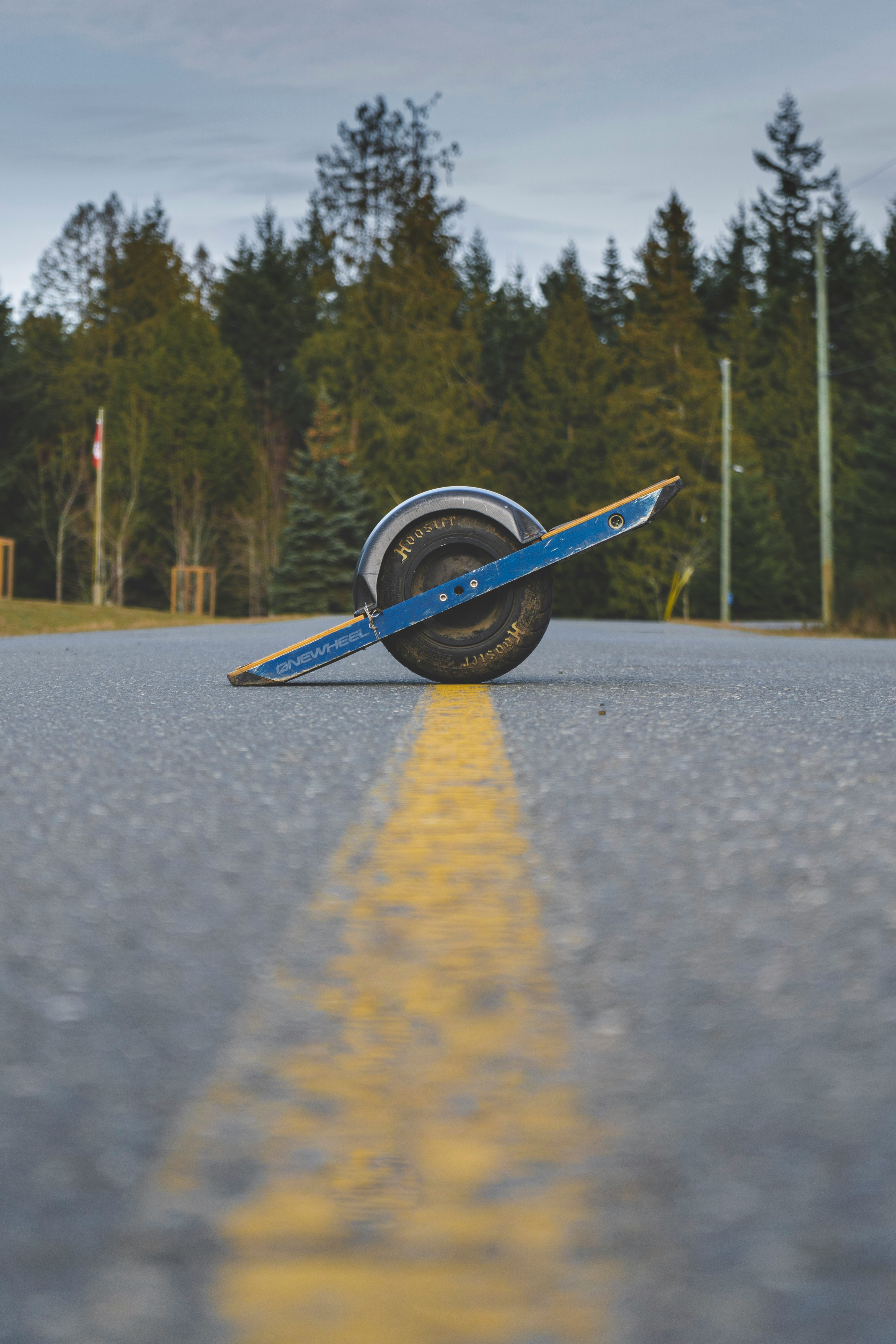 blue and white boat on gray asphalt road during daytime